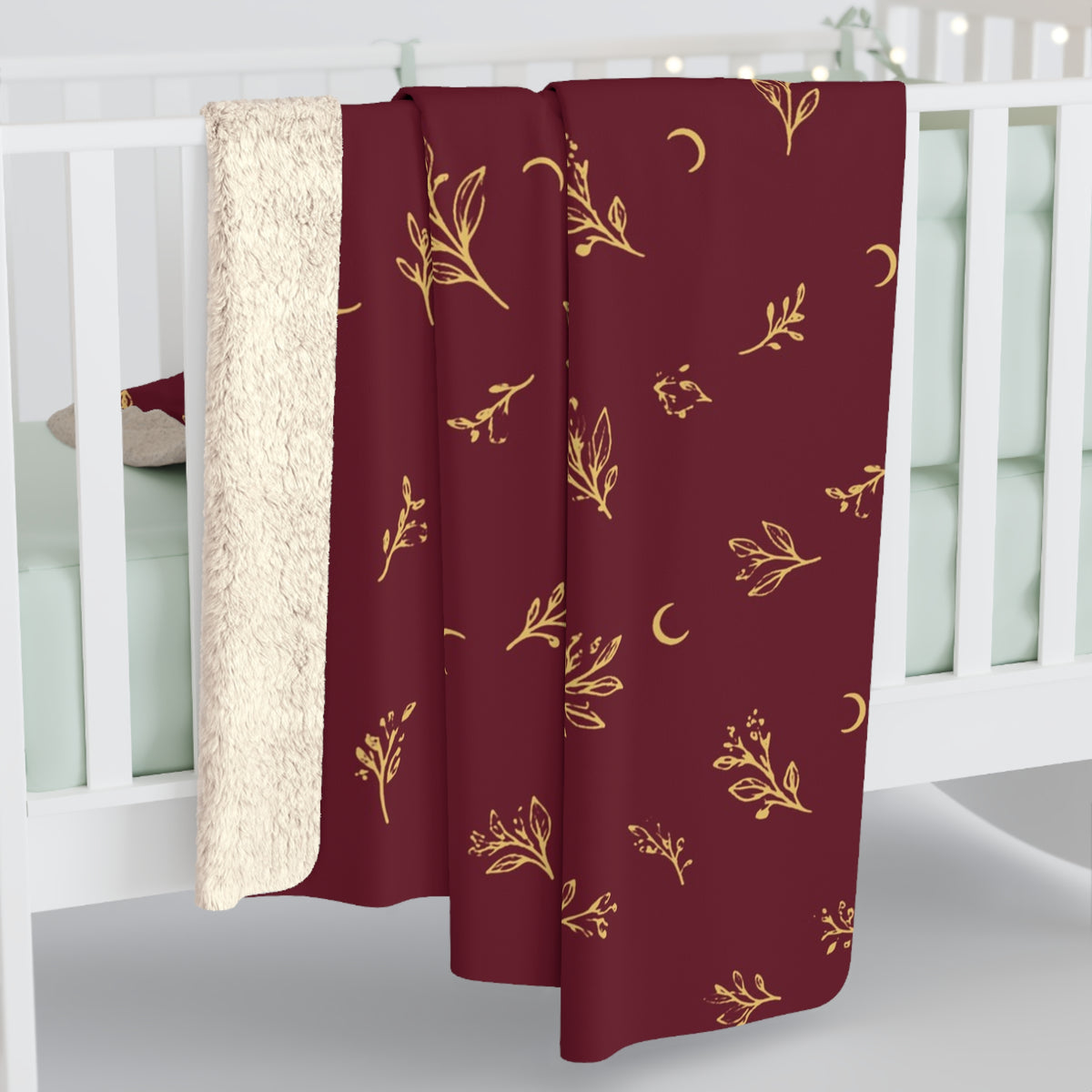 Cranberry Gold sherpa blanket hanging over a crib rail, cream sherpa back showing (larger size)