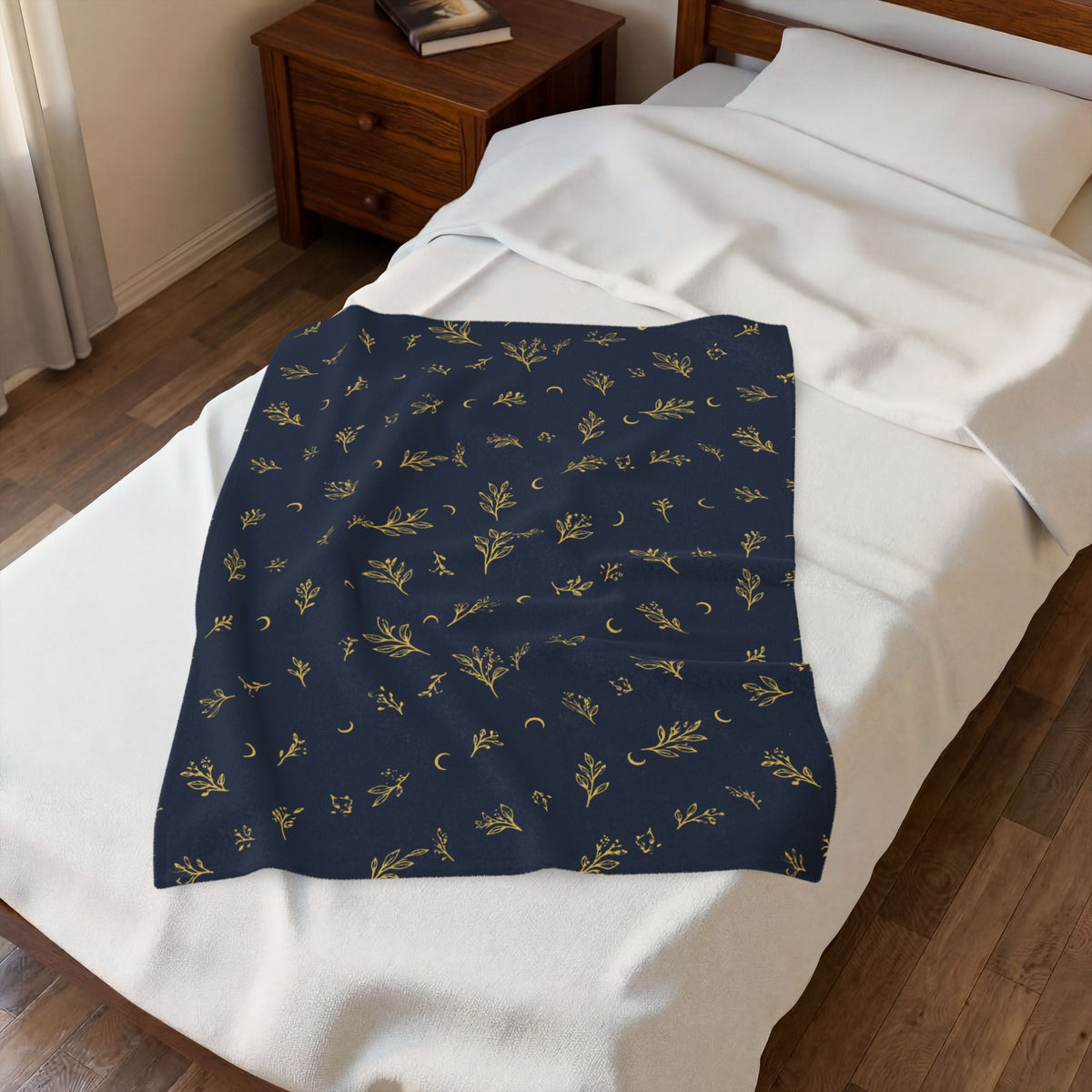 Navy Gold plush blanket laid on a white bed, seen from above