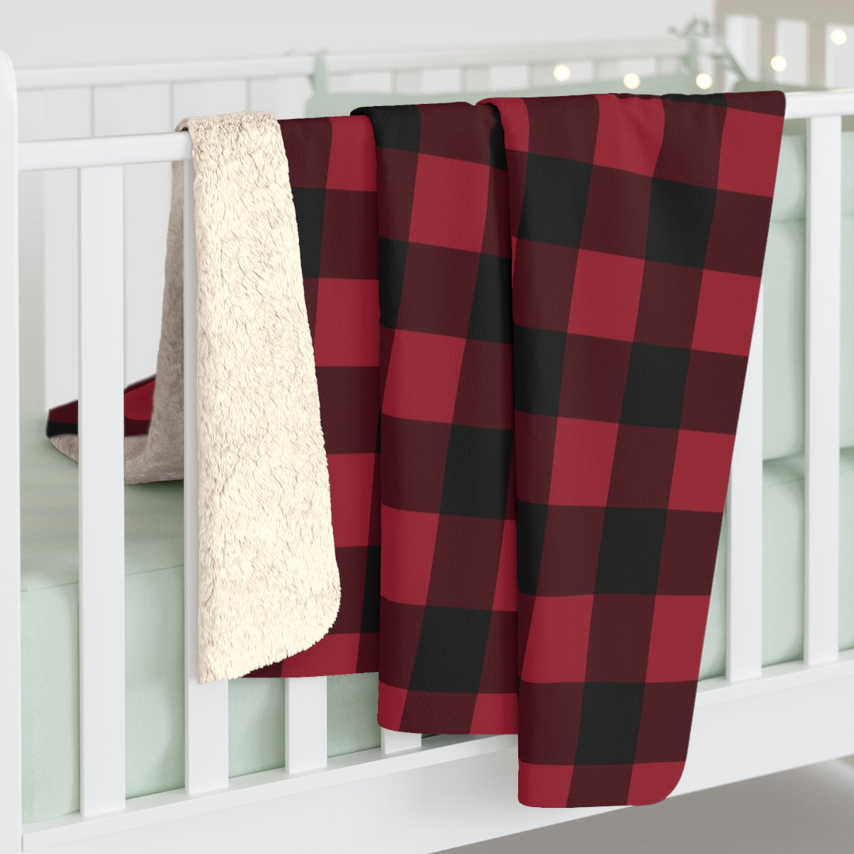 Cranberry Buffalo Check sherpa blanket hanging over a crib rail, cream sherpa back showing