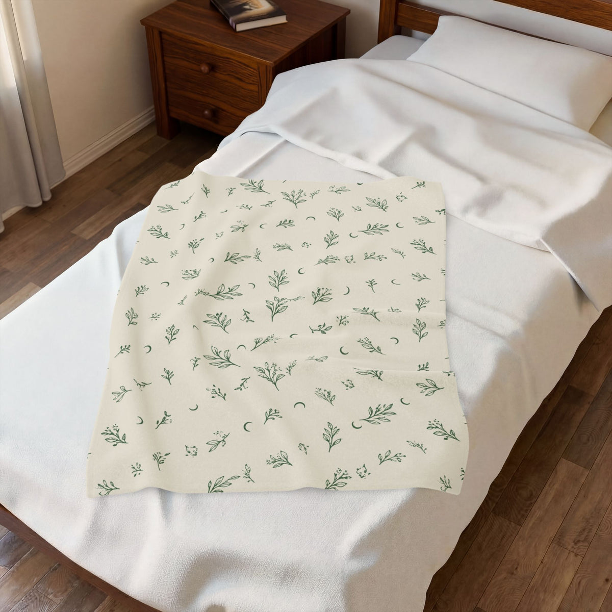 Cream Sage plush blanket laid on a white bed, seen from above